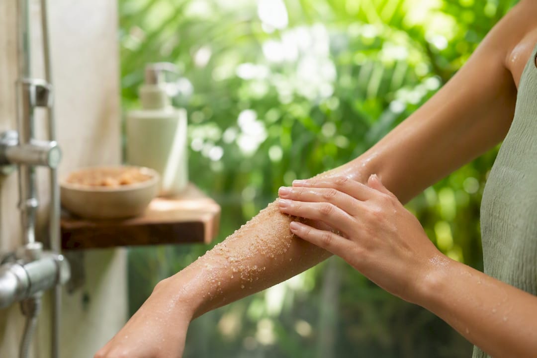 Applying gentle exfoliating sugar scrub to forearm