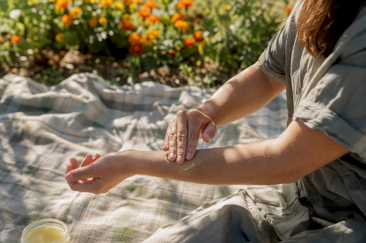 Person applying mosquito repellent balm on arm