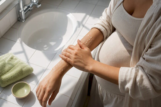 Pregnant person gently exfoliating forearm