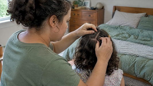 Caregiver parts child's hair to check scalp