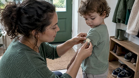 Caregiver applies mosquito patch to child's shirt
