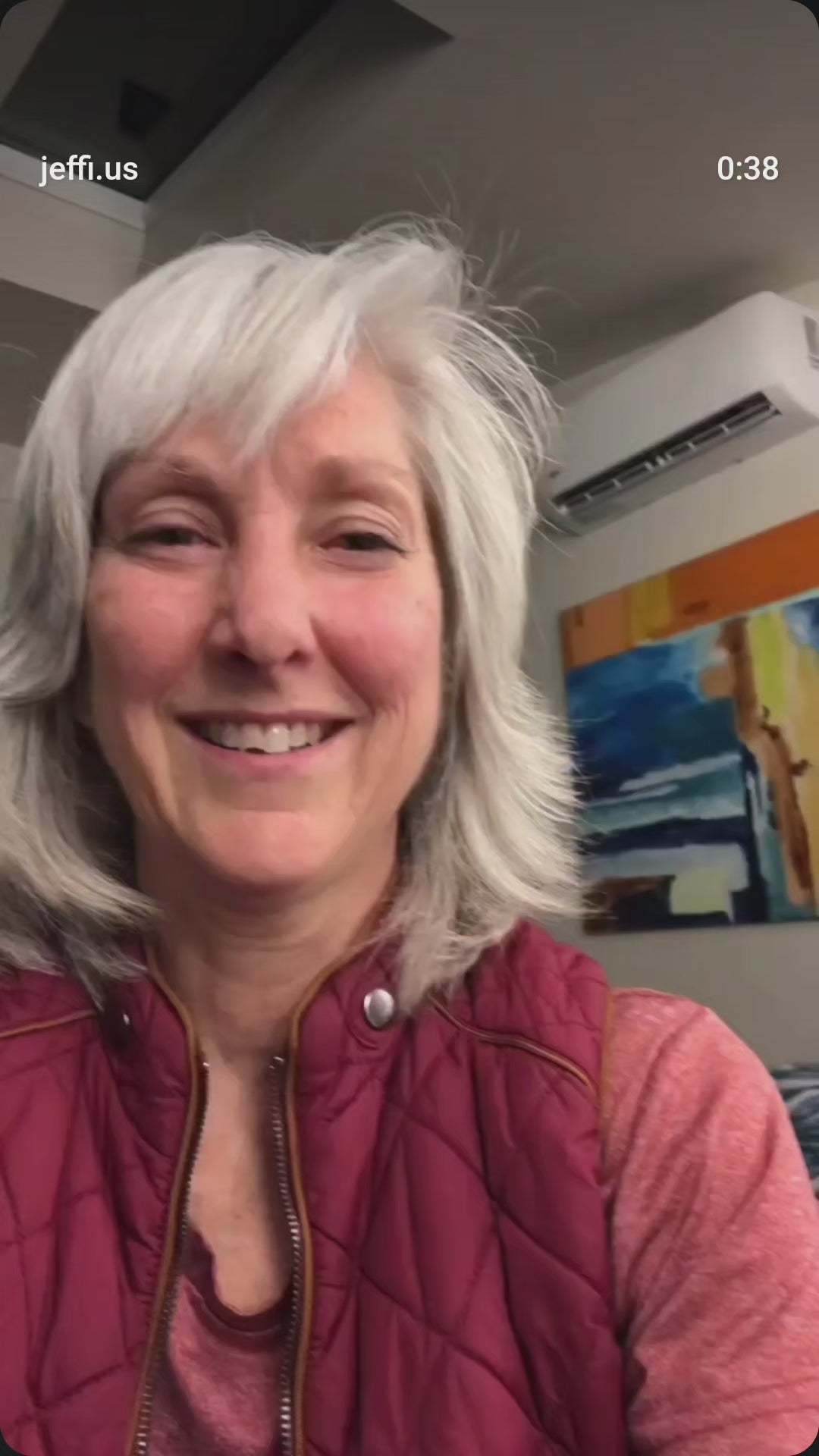 Load video: A silver-haired customer in a red puffy jacket shares her experience with Jeffi, smiling as she speaks.